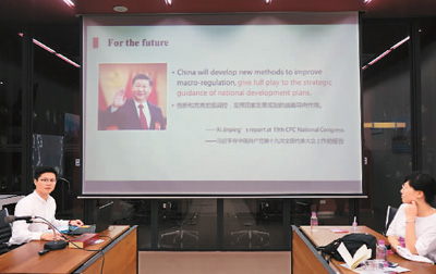 在泰國(guó)朱拉隆功大學(xué)，清華大學(xué)公共管理學(xué)院博士生石智丹（左）用英文講解中國(guó)國(guó)家治理中的五年規(guī)劃 　　霍元東攝