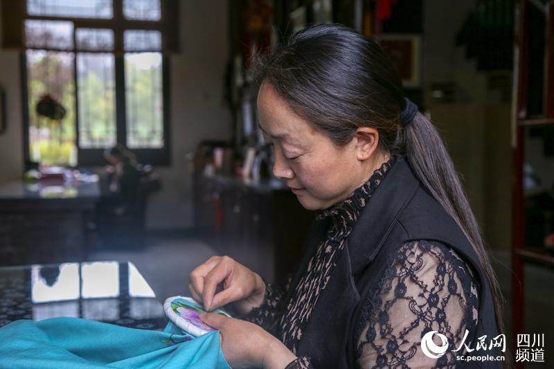 在北川非物質(zhì)文化遺產(chǎn)保護中心做羌繡的陳云珍。（朱虹 攝）