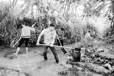 在脫貧攻堅(jiān)戰(zhàn)場(chǎng)上，一大批黨員干部奔赴第一線，帶領(lǐng)群眾一步步實(shí)現(xiàn)脫貧夢(mèng)想，詮釋著共產(chǎn)黨人的初心與使命。圖為廣西壯族自治區(qū)興業(yè)縣小平山鎮(zhèn)金華村駐村第一書記董積有（左二）帶領(lǐng)村民清理河道中的淤泥和垃圾。 新華社記者 曹祎銘 攝