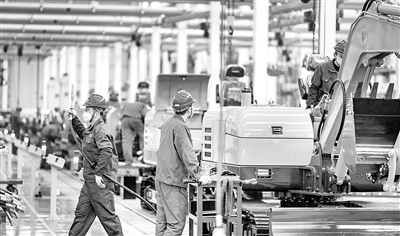 圖為近日，在湖南長沙三一集團的廠房內(nèi)，工人們正在有序開展生產(chǎn)。（資料圖片）