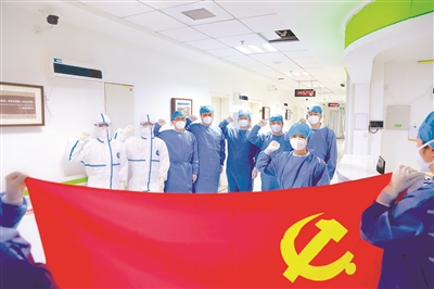 在抗擊疫情的重大斗爭中，各級黨組織和廣大黨員、干部堅決貫徹黨中央決策部署，牢記人民利益高于一切，挺身而出、英勇奮戰(zhàn)，鮮紅的黨旗在戰(zhàn)疫一線高高飄揚。圖為1月29日，中部戰(zhàn)區(qū)總醫(yī)院抗疫一線黨員在黨旗前集體宣誓，表達沖鋒在前堅決打贏疫情防控阻擊戰(zhàn)的決心。姚堯 攝