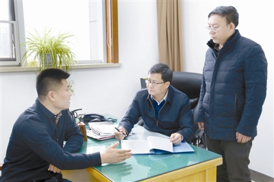 圖為周躍武(中)與室里同志在討論研究案件。高小軍 攝