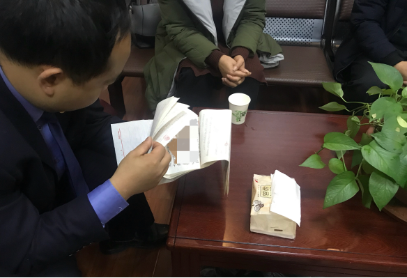 當晚李明寫了整整11頁紙的交代材料?；ㄔh紀委、縣監(jiān)委工作人員在翻看李明所寫的交代材料