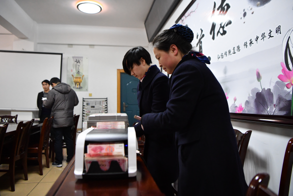 工作人員在現(xiàn)場清點違紀款