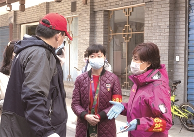 湖北省襄陽市水星臺(tái)社區(qū)黨委書記劉曉琳（右一）在和社區(qū)工作人員交流防疫工作。  新華社發(fā)（謝劍飛 攝）