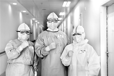 圖為湘雅醫(yī)院第七黨總支紀(jì)檢委員錢招昕(中)和援鄂醫(yī)療隊在武漢協(xié)和醫(yī)院西院區(qū)重癥病房內(nèi)相互鼓勵