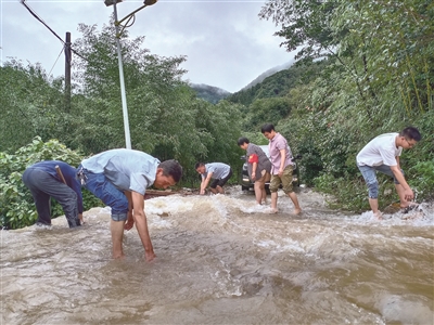浙江省淳安縣屏門鄉(xiāng)紀(jì)委書記方慧月（右二）到聯(lián)系點(diǎn)天坪村開展防汛巡查途中，道路受塌方影響被堵，她隨即同當(dāng)?shù)攸h員干部一起疏通道路，恢復(fù)交通。趙桂興 攝