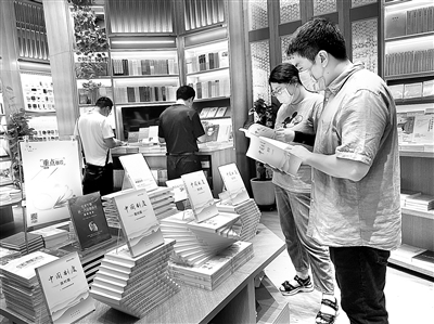 ▶圖為讀者近日在人民出版社旗艦店設(shè)置的重點(diǎn)推薦展臺(tái)前閱讀。 (人民出版社供圖)