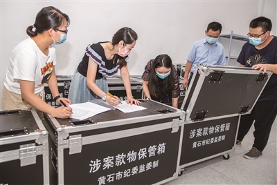 圖為湖北省黃石市紀(jì)委監(jiān)委審查調(diào)查人員移交登記暫扣的涉案物品。何戈 攝