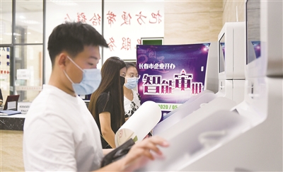 長春市企業(yè)開辦智能審批系統(tǒng)自5月18日上線以來，通過智能化審批新設(shè)立599戶市場主體，其中企業(yè)313戶，個體工商戶286戶。該系統(tǒng)代替?zhèn)鹘y(tǒng)人工審批模式，實現(xiàn)企業(yè)開辦登記全程零見面、零跑動、零干預(yù)。圖為市民在長春市朝陽區(qū)政務(wù)大廳內(nèi)的企業(yè)開辦智能審批一體機上辦理業(yè)務(wù)。新華社記者 顏麟蘊 攝