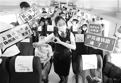 7月1日，滬蘇通鐵路開通運營，縮短了上海與南通以及蘇北地區(qū)的時空距離，有力助推長三角一體化發(fā)展。圖為當(dāng)日，首趟列車C3836次動車乘務(wù)員在車廂內(nèi)為旅客表演節(jié)目。 新華社記者 陳飛 攝