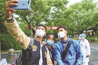 10月13日，刑法修正案（十一）草案二審稿提請(qǐng)十三屆全國(guó)人大常委會(huì)會(huì)議審議。草案規(guī)定，冒名頂替上大學(xué)擬入刑。圖為9月19日，中南民族大學(xué)2020年級(jí)新生開始入學(xué)報(bào)到。從深山中走出的少數(shù)民族大一新生拉毛東智、群熱吉和關(guān)卻才讓（從左至右）在校園內(nèi)拍照留念。新華社記者 劉金海 攝