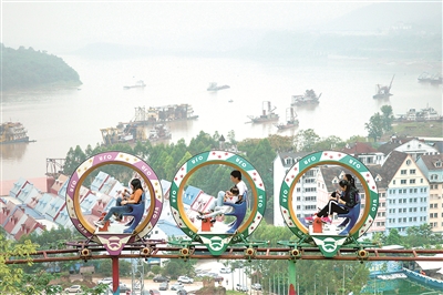 “生態(tài)產(chǎn)業(yè)化、產(chǎn)業(yè)生態(tài)化”，讓生態(tài)和經(jīng)濟在平衡中整體性推進。重慶作為長江上游重要的生態(tài)廊道，堅持系統(tǒng)觀念，運用系統(tǒng)方法，在生態(tài)保護和經(jīng)濟發(fā)展中尋求動態(tài)平衡。圖為游客在重慶市涪陵區(qū)美心紅酒小鎮(zhèn)乘坐高空腳踏車休閑游覽，眺望潮平水闊。 新華社記者 劉潺 攝