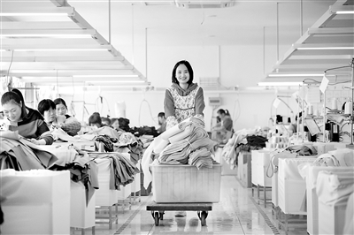 近年來，江蘇南通董王村利用省級扶貧項(xiàng)目工業(yè)園、勞動力等優(yōu)惠政策，建立扶貧車間，發(fā)展制衣、建材等企業(yè)，累計(jì)帶動貧困戶80余人在家門口就業(yè)，實(shí)現(xiàn)脫貧增收。圖為11月4日，工人在該村沽然時(shí)裝有限公司內(nèi)趕制出口的服裝訂單。（圖片來源：人民視覺）