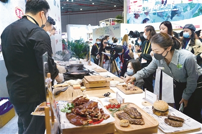 在國別數(shù)最多的食品及農(nóng)產(chǎn)品展區(qū)，觀展人員在試吃現(xiàn)場烹飪的香煎谷飼西冷牛排。姜永斌 攝