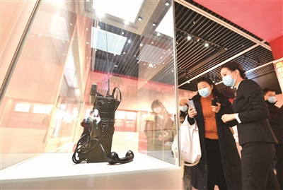 日前，“紅色電波中的領(lǐng)袖風(fēng)范——毛澤東同志香山時(shí)期發(fā)布電報(bào)手稿”專(zhuān)題展覽在北京香山革命紀(jì)念館舉行。圖為觀眾在觀看拍攝展出的電臺(tái)。（圖片來(lái)源：人民視覺(jué)）