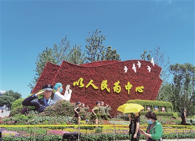 北京市長(zhǎng)安街西單路口東北角以寫有“以人民為中心”的紅旗為主景的花壇。  本報(bào)記者 黃秋霞 攝