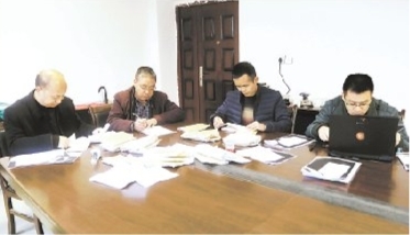 寧化縣紀(jì)委紀(jì)律審查組正在查閱延祥村賬本。