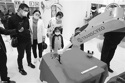 近日，2020中國（南京）文化和科技融合成果展覽交易會在江蘇南京舉行。圖為參觀者在觀看機器人表演書法。（圖片來源：環(huán)球網(wǎng)）