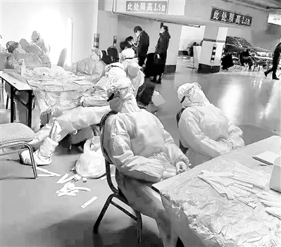 圖為醫(yī)護(hù)人員在石家莊槐底社區(qū)開展核酸檢測(cè)，他們?cè)诠ぷ鏖g隙稍作休息。胡一刀 攝