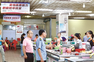 圖為海南省昌江縣紀(jì)委監(jiān)委聯(lián)合縣市場(chǎng)監(jiān)督管理局在曾經(jīng)被黃鴻發(fā)集團(tuán)長(zhǎng)期把持的縣中心農(nóng)貿(mào)市場(chǎng)走訪調(diào)研，向經(jīng)營(yíng)戶了解黃鴻發(fā)黑社會(huì)性質(zhì)組織被成功打掉后農(nóng)貿(mào)市場(chǎng)整體環(huán)境的變化。文承彬 攝